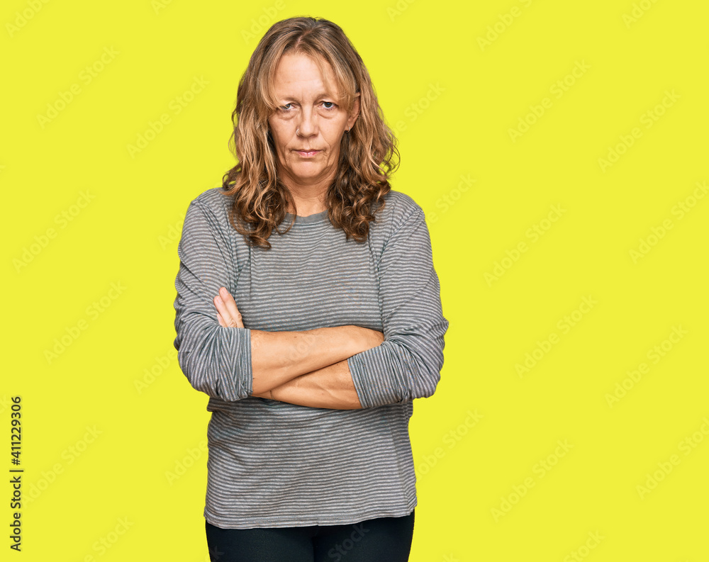 Middle age blonde woman wearing casual clothes skeptic and nervous, disapproving expression on face with crossed arms. negative person. Middle age blonde woman wearing casual clothes skeptic and nervous, disapproving expression on face with crossed arms. negative person.