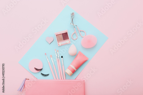Makeup tools and accessories on blue and pink background. Beauty concept. Flat lay composition, top view