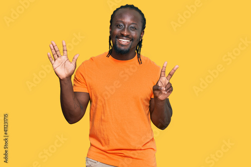 Handsome young african american man wearing casual clothes showing and pointing up with fingers number seven while smiling confident and happy.