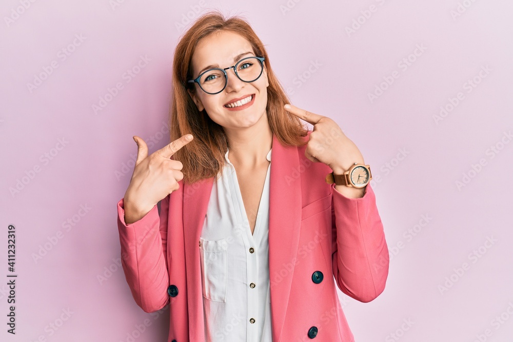 Young caucasian woman wearing business style and glasses smiling cheerful showing and pointing with fingers teeth and mouth. dental health concept.