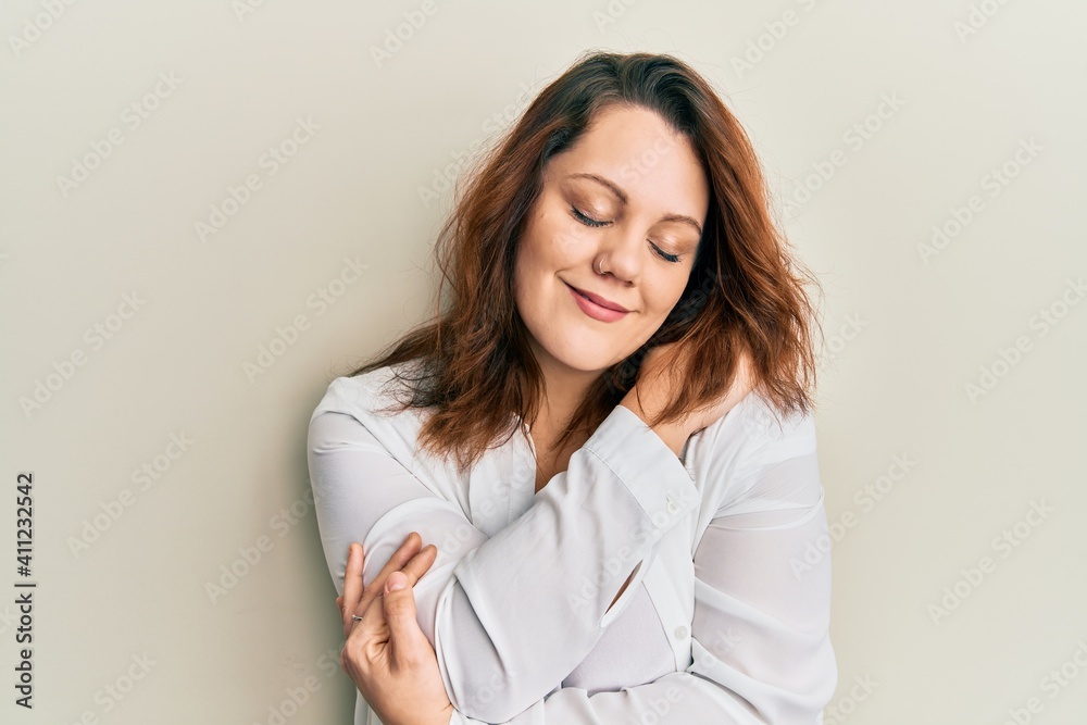 Young caucasian woman wearing casual clothes hugging oneself happy and positive, smiling confident. self love and self care Young caucasian woman wearing casual clothes hugging oneself happy and positive, smiling confident. self love and self care