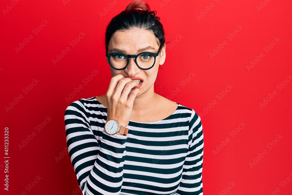 Young caucasian woman wearing casual clothes and glasses looking stressed and nervous with hands on mouth biting nails. anxiety problem.