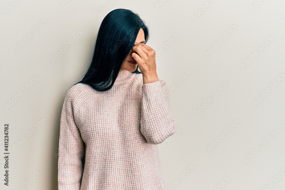 Young caucasian woman wearing casual winter sweater tired rubbing nose and eyes feeling fatigue and headache. stress and frustration concept. Young caucasian woman wearing casual winter sweater tired rubbing nose and eyes feeling fatigue and headache. stress and frustration concept.