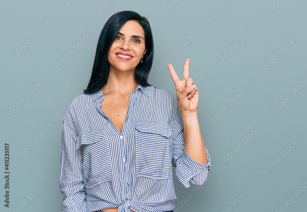 Young caucasian woman wearing casual clothes showing and pointing up with fingers number two while smiling confident and happy. Young caucasian woman wearing casual clothes showing and pointing up with fingers number two while smiling confident and happy.