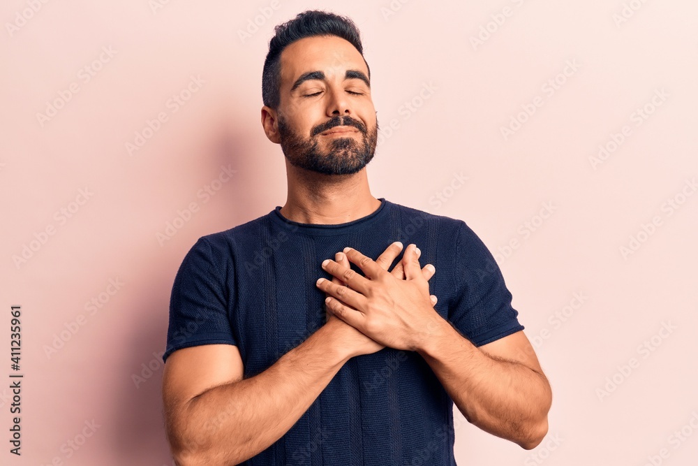 Young hispanic man wearing casual clothes smiling with hands on chest, eyes closed with grateful gesture on face. health concept. Young hispanic man wearing casual clothes smiling with hands on chest, eyes closed with grateful gesture on face. health concept.