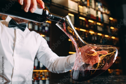 Young handsome man sommelier tasting red wine in cellar. photo