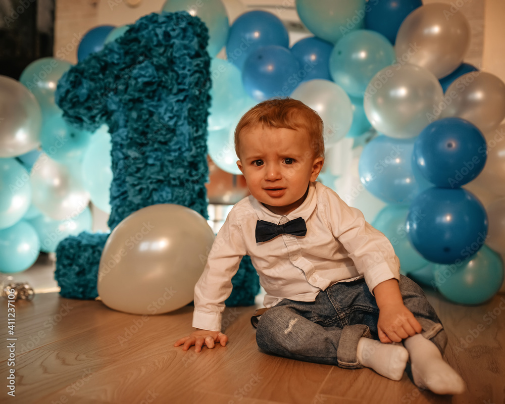 baby child with balloons having his birthday against blue balloons baby child with balloons having his birthday against blue balloons