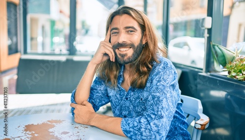 Fotografia Young middle eastern man smiling happy sitting at the coffee shop terrace