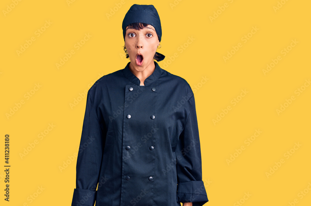 Young brunette woman with short hair wearing professional cook uniform afraid and shocked with surprise expression, fear and excited face. Young brunette woman with short hair wearing professional cook uniform afraid and shocked with surprise expression, fear and excited face.