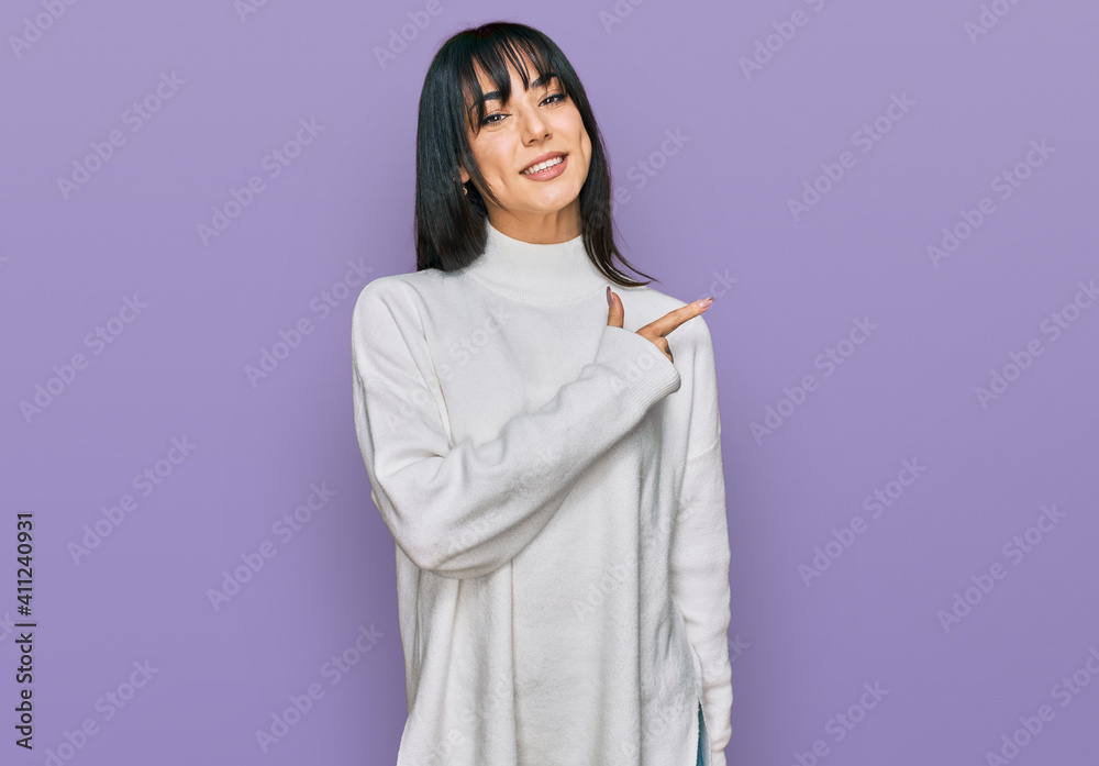 Young brunette woman with bangs wearing casual turtleneck sweater cheerful with a smile of face pointing with hand and finger up to the side with happy and natural expression on face Young brunette woman with bangs wearing casual turtleneck sweater cheerful with a smile of face pointing with hand and finger up to the side with happy and natural expression on face