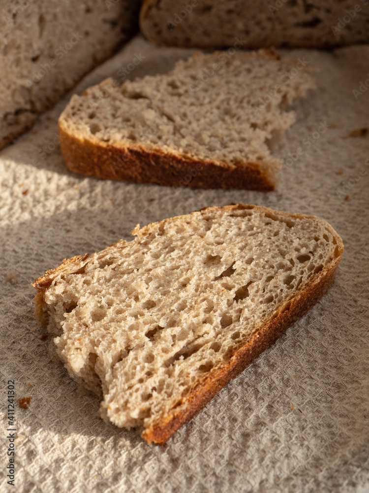 Homemade fresh wheat-rye bread on sourdough on a natural color linen napkin on a white background in the morning light Homemade fresh wheat-rye bread on sourdough on a natural color linen napkin on a white background in the morning light