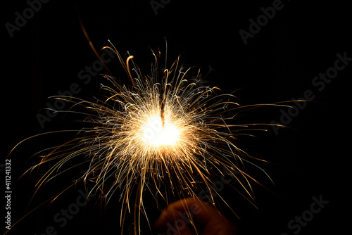 New year sparkler in hands on black background