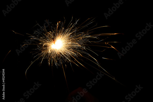 New year sparkler in hands on black background