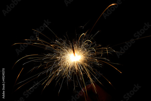 New year sparkler in hands on black background