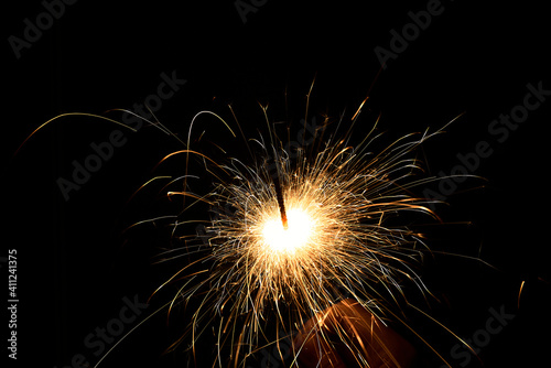New year sparkler in hands on black background