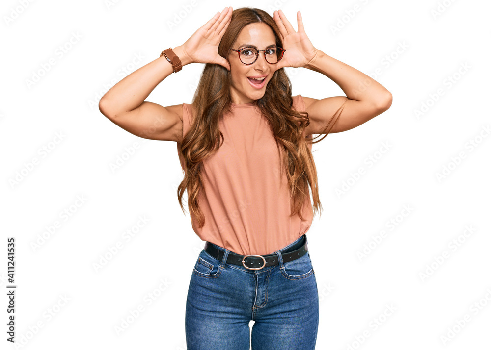Young hispanic woman wearing casual clothes and glasses smiling cheerful playing peek a boo with hands showing face. surprised and exited Young hispanic woman wearing casual clothes and glasses smiling cheerful playing peek a boo with hands showing face. surprised and exited