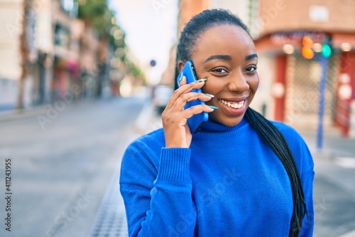 Young african american woman smiling happy talking on the smartphone at the city.