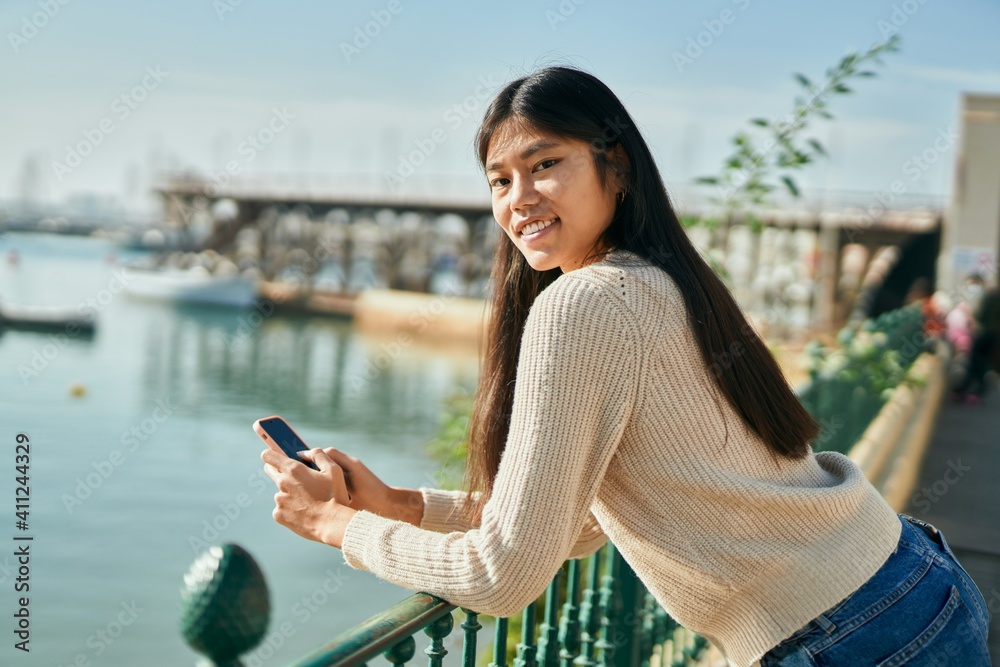 Young asian woman smiling happy using smartphone at the city.