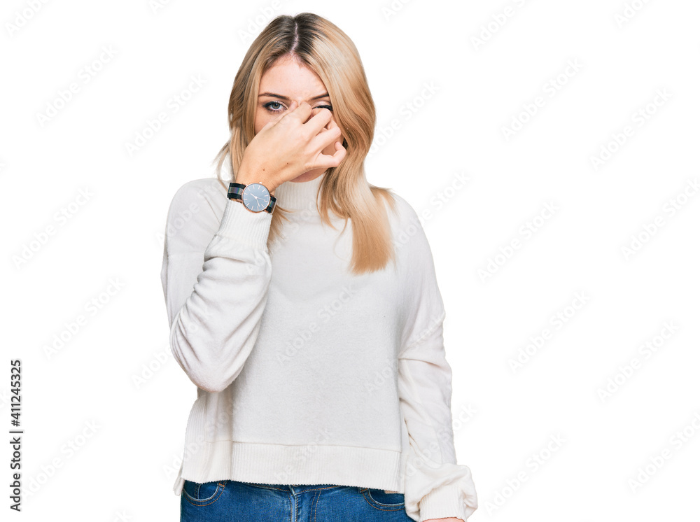 Young caucasian woman wearing casual winter sweater tired rubbing nose and eyes feeling fatigue and headache. stress and frustration concept. Young caucasian woman wearing casual winter sweater tired rubbing nose and eyes feeling fatigue and headache. stress and frustration concept.