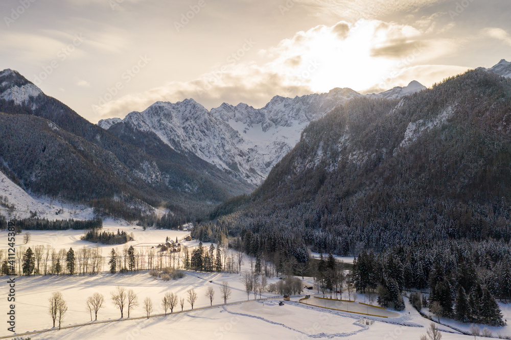 Aerial winter landscape with mountain village and forest covered in snow. Zgornje Jezersko, Slovenia.