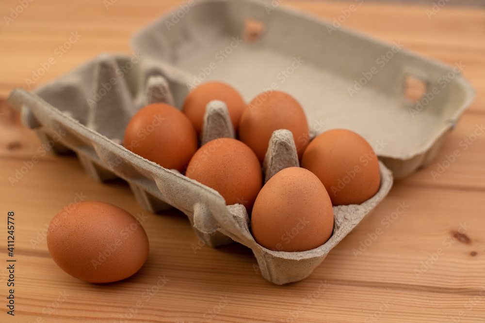 eggs in a package on a wooden table, ingredients eggs in a package on a wooden table, ingredients