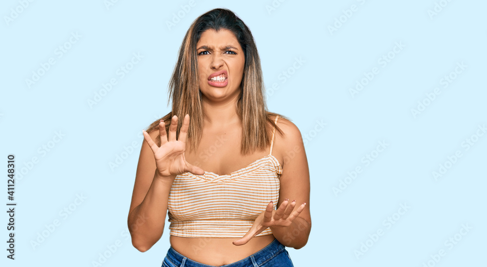 Beautiful brunette woman wearing casual clothes disgusted expression, displeased and fearful doing disgust face because aversion reaction. with hands raised Beautiful brunette woman wearing casual clothes disgusted expression, displeased and fearful doing disgust face because aversion reaction. with hands raised