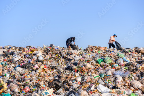 Poor people collect garbage for sale People living in garbage heaps walking to collect recyclable waste to be sold to poverty concept world environment day photo