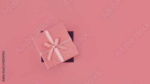 pink holiday box with bow on pink background, banner, 16:9 © ksenija1803z