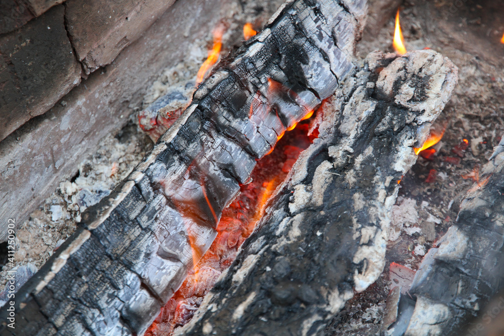 Glowing embers in hot red color, abstract background. The hot embers of burning wood log fire. Firewood burning on grill. Texture fire bonfire embers. Glowing embers in hot red color, abstract background. The hot embers of burning wood log fire. Firewood burning on grill. Texture fire bonfire embers.