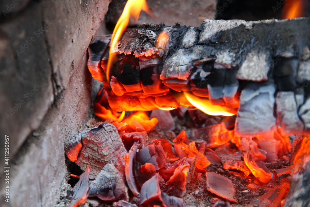 Glowing embers in hot red color, abstract background. The hot embers of burning wood log fire. Firewood burning on grill. Texture fire bonfire embers. Glowing embers in hot red color, abstract background. The hot embers of burning wood log fire. Firewood burning on grill. Texture fire bonfire embers.