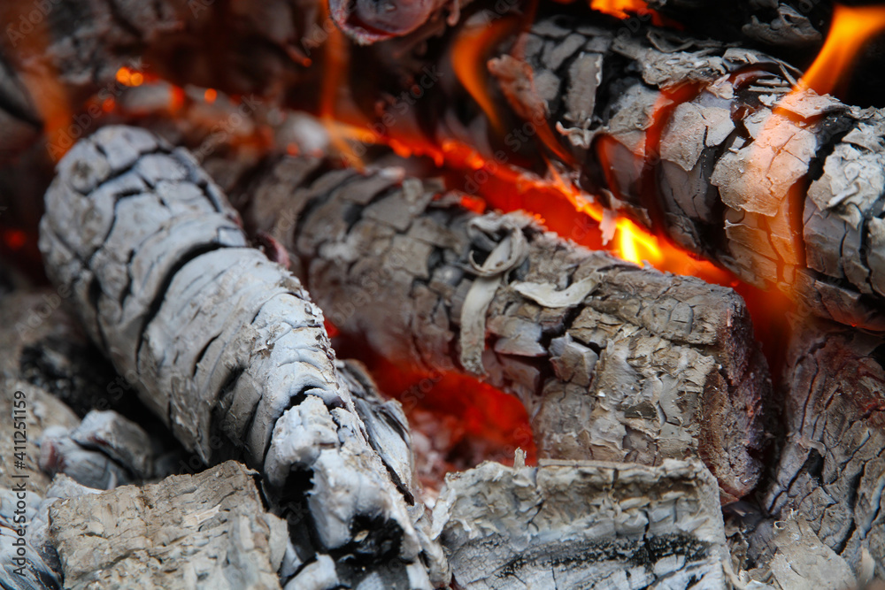 Glowing embers in hot red color, abstract background. The hot embers of burning wood log fire. Firewood burning on grill. Texture fire bonfire embers. Glowing embers in hot red color, abstract background. The hot embers of burning wood log fire. Firewood burning on grill. Texture fire bonfire embers.