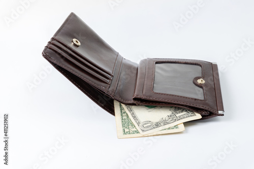 Leather wallet with one single dollar on a white background.