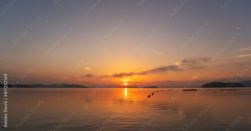 Beautiful sunset or sunrise with dramatic colorful sky clouds over calm sea and reflection in water surface tropical island Amazing nature view and light of nature