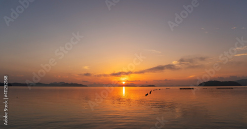 Beautiful sunset or sunrise with dramatic colorful sky clouds over calm sea and reflection in water surface tropical island Amazing nature view and light of nature