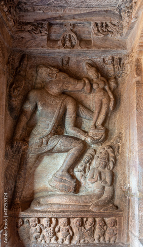 Badami, Karnataka, India - November 7, 2013: Cave temples above Agasthya Lake. Brown stone sculpture featuring Vishnu as Varaha rescuing Earth as Bhudevi.