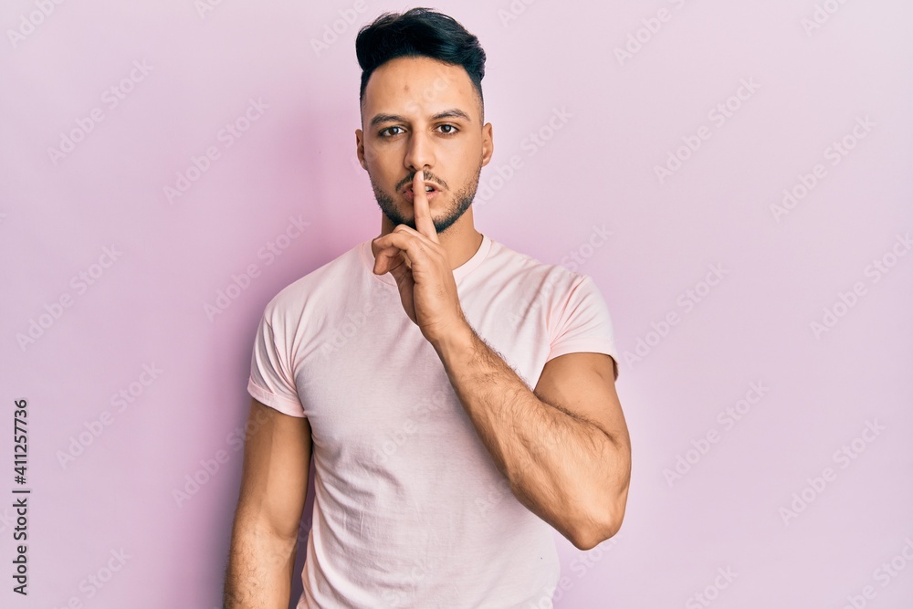 Young arab man wearing casual clothes asking to be quiet with finger on lips. silence and secret concept. Young arab man wearing casual clothes asking to be quiet with finger on lips. silence and secret concept.