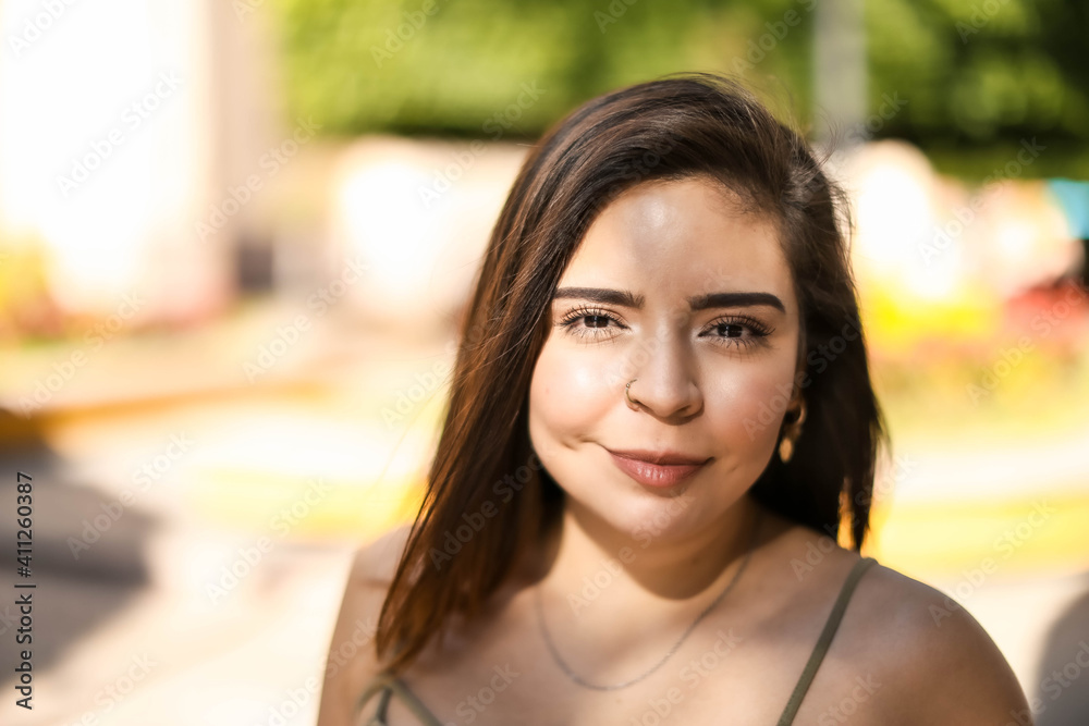 Beautiful healthy young woman smiling with his finger pointing and looking at on light, and camera
