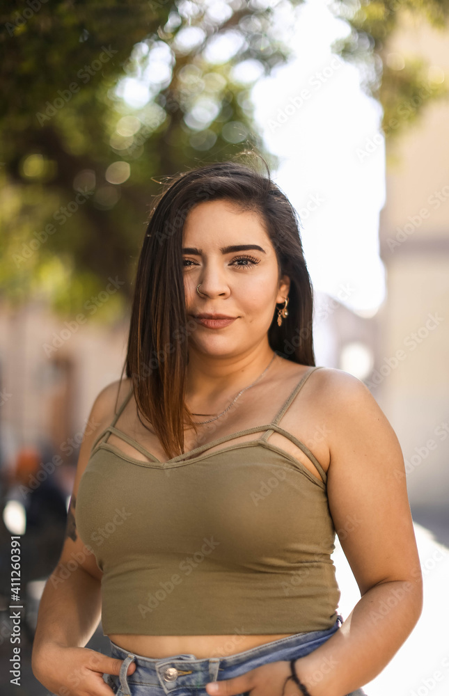 Beautiful healthy young woman smiling with his finger pointing and looking at on light, and camera Beautiful healthy young woman smiling with his finger pointing and looking at on light, and camera