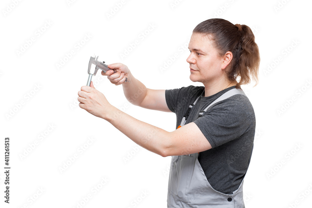 male mechanic in gray uniform holds bolt and caliper in hands caliper is taking control measurement of the size of steel iron part with thread for car repair isolated on white background. male mechanic in gray uniform holds bolt and caliper in hands caliper is taking control measurement of the size of steel iron part with thread for car repair isolated on white background.