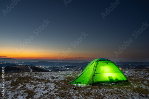 Tent on the background of the sunrise in winter in the mountains