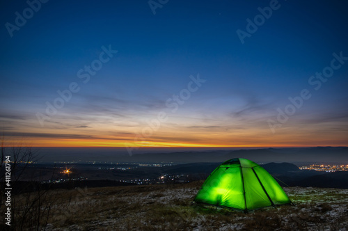 Tent on the background of the sunrise in winter in the mountains