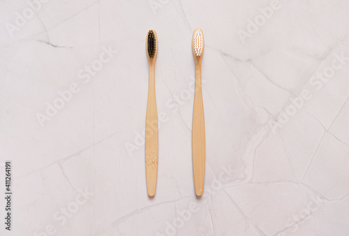 Family set of two bamboo toothbrushes for the whole family on a white marble background. Concept for a natural organic oral care product. Zero waste concept. A plastic-free future. copy space.top view