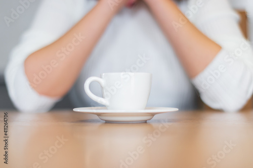 woman in turkish coffee and white sweater standing on wooden table