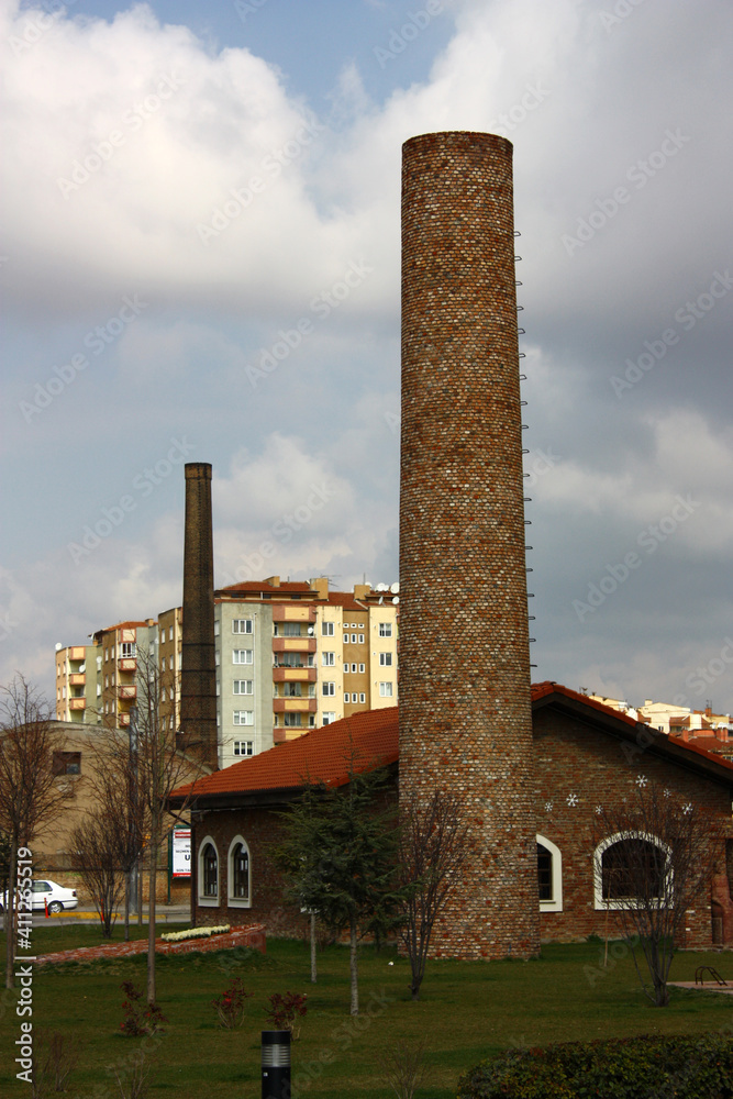 Very high and old factory chimney made by red bricks.
