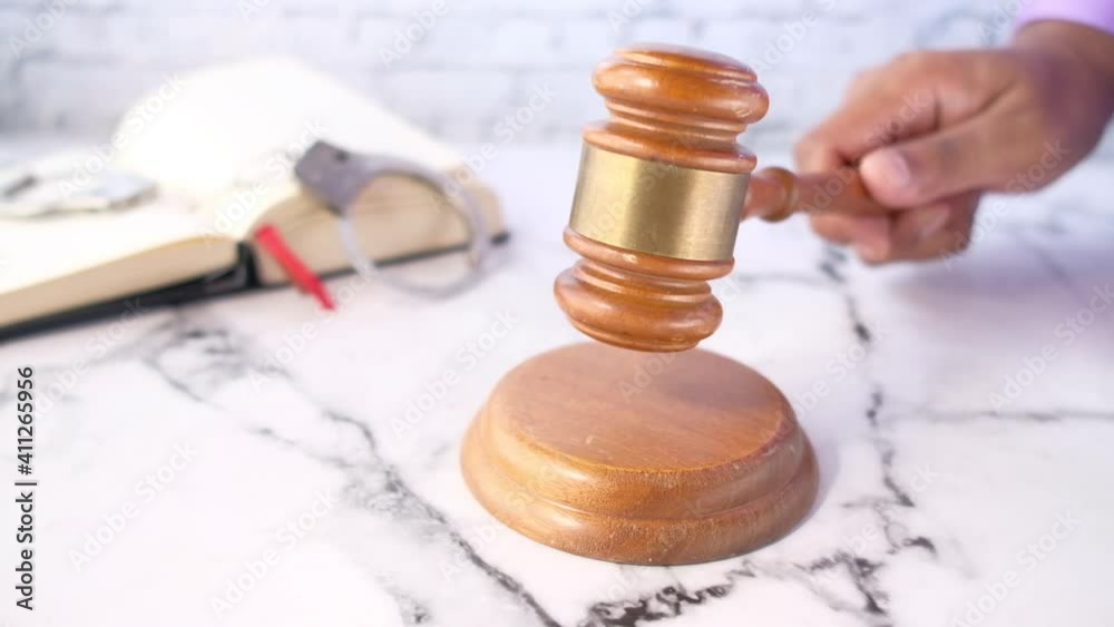 close up of person's hand striking the gavel. close up of person's hand striking the gavel.