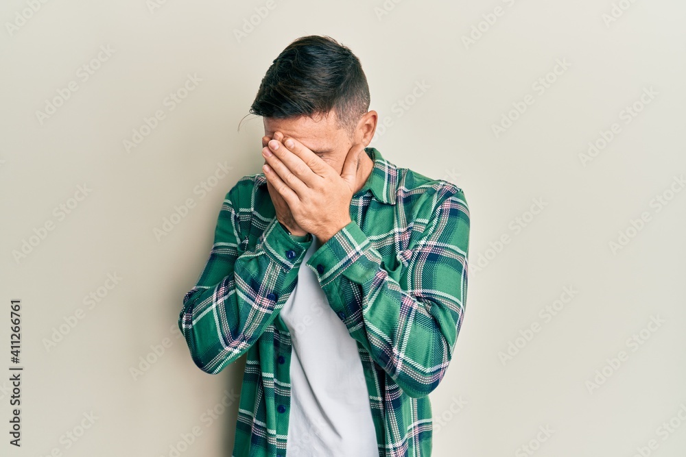 Fototapeta premium Handsome man with beard wearing casual clothes with sad expression covering face with hands while crying. depression concept.