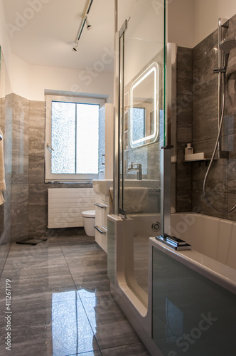 Blick von der Tür in ein Badezimmer , mit einer altersgerechten Ausstattung. Badewanne mit Einstieg und Duschfunktion