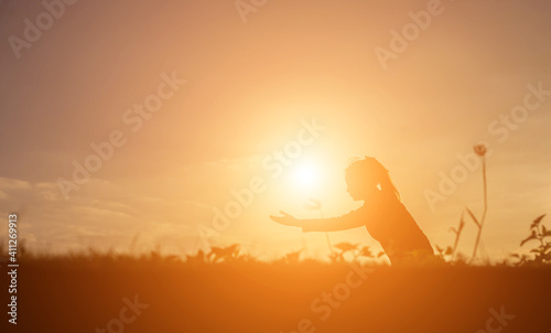 Silhouette of woman praying over beautiful sky background © JUTARAT