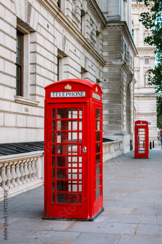 Old traditional red telephone booth on a street in the city of London