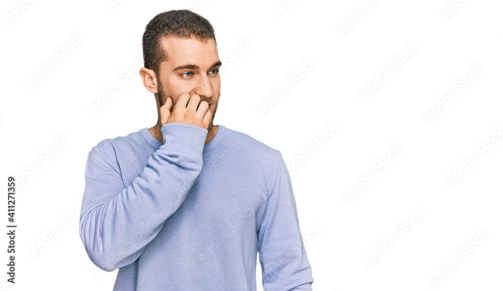 Young caucasian man wearing casual clothes looking stressed and nervous with hands on mouth biting nails. anxiety problem. Young caucasian man wearing casual clothes looking stressed and nervous with hands on mouth biting nails. anxiety problem.